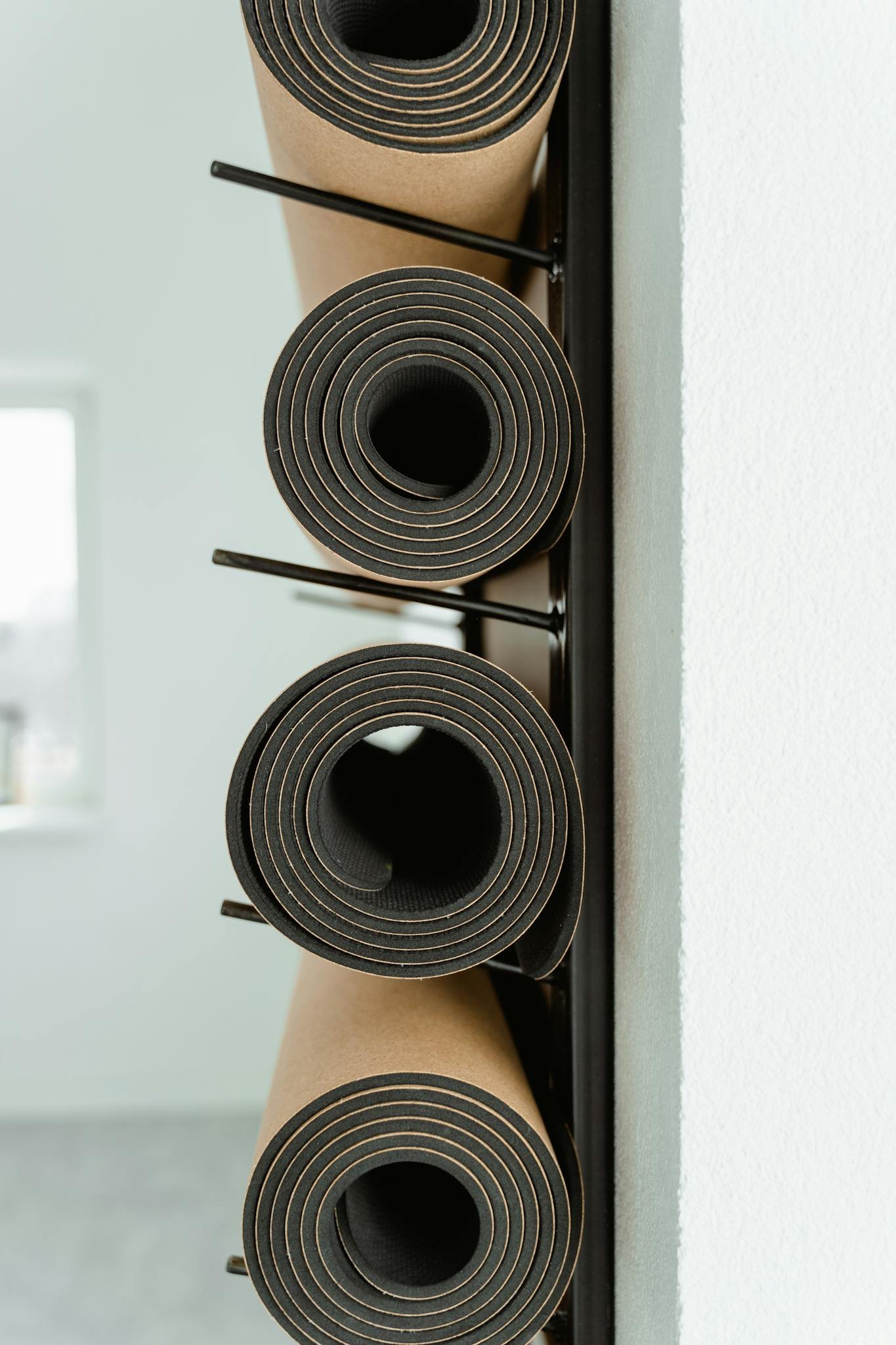 An artistic view of stacked yoga mats in a modern minimalist indoor space.